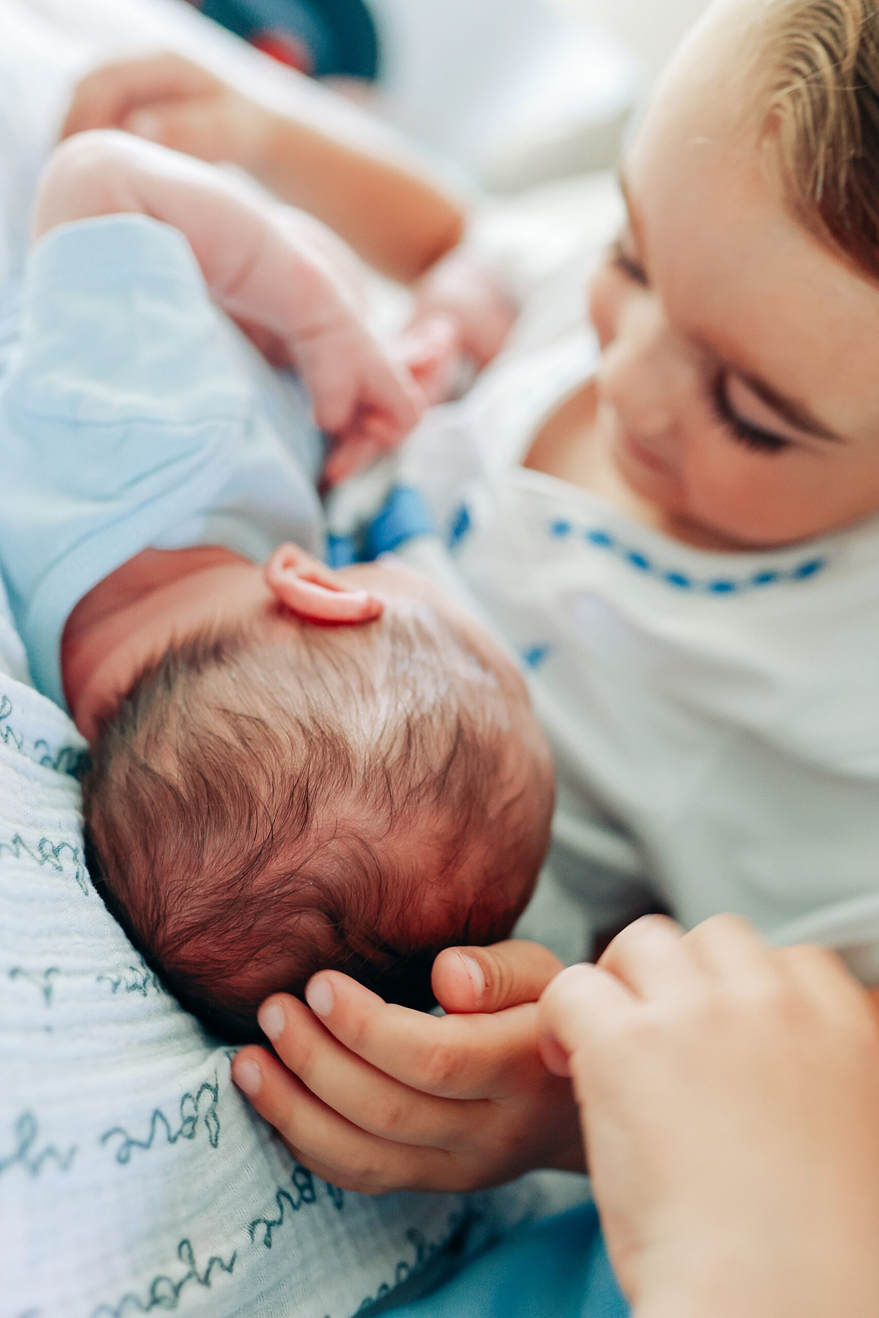 when should I book newborn photos - baby with big brother